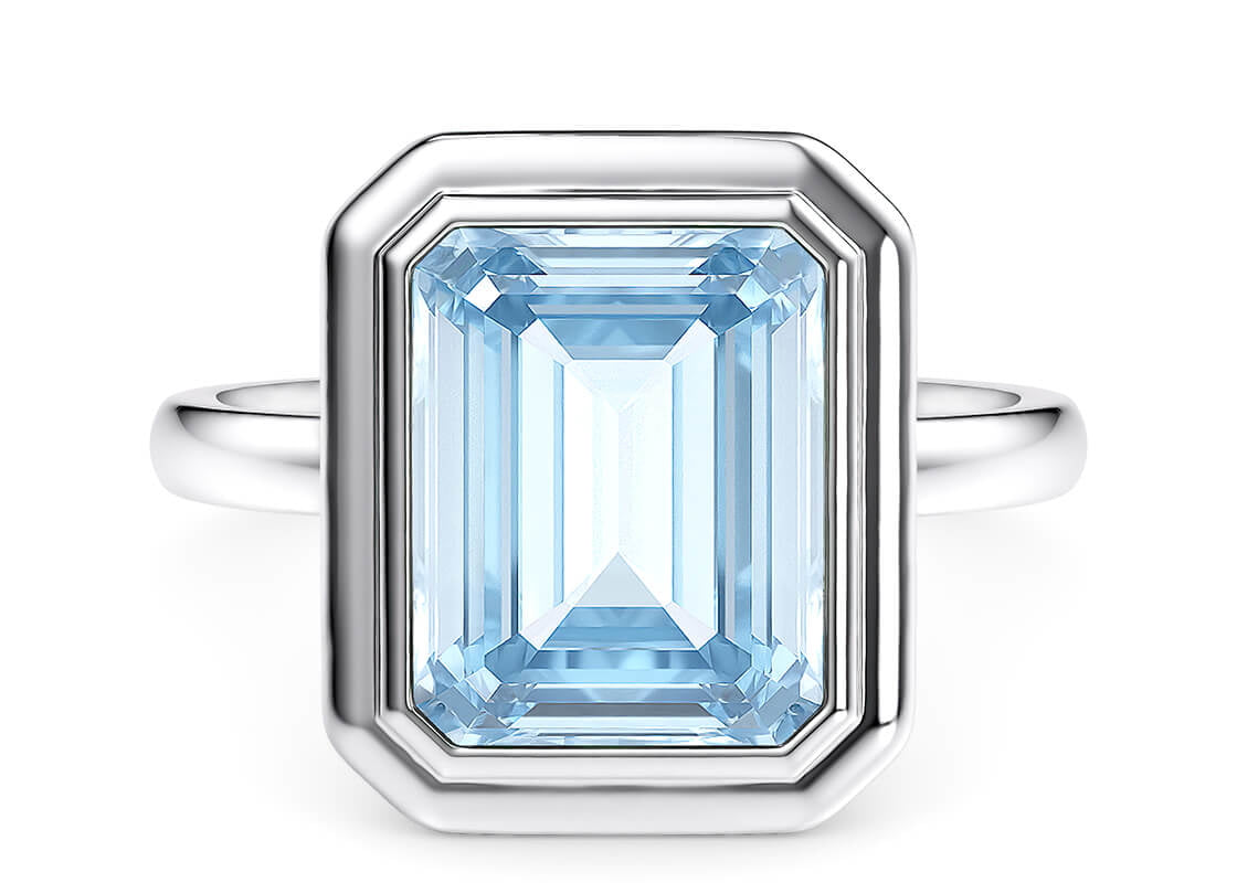 This design highlights the stunning colour of the gemstone by showcasing a striking octagon-shaped aquamarine at its center. Framed by a double-stepped bezel, the piece combines clear, crisp lines with timeless sophistication.