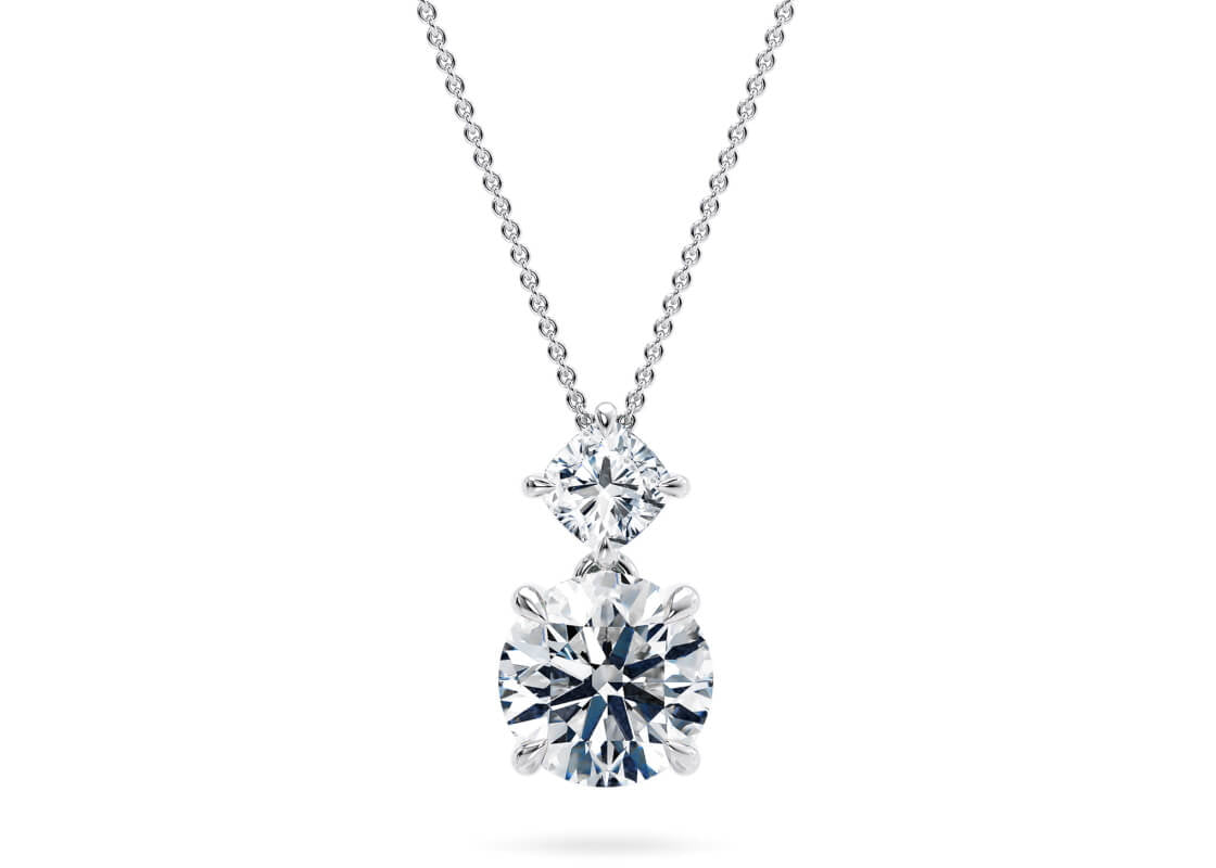 Let your chosen centre stone shine, gently suspended beneath a compass-set cushion diamond that echoes the brilliance of a guiding star. A refined design that captures the essence of celestial beauty with every glimmer.