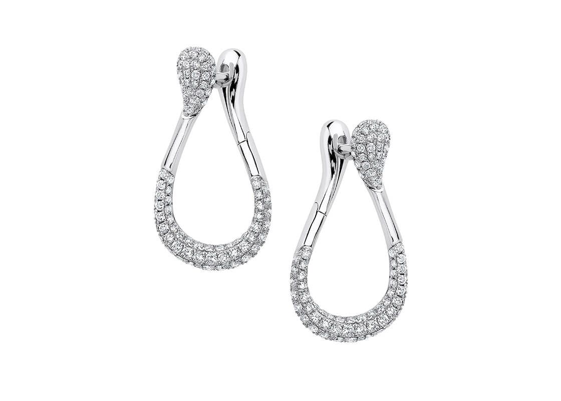 The Seren Diamond Hoops feature a graceful wrap-around design that brings fluidity and elegance to your look. Adorned with intricately set round brilliant diamonds, they add a striking touch to any ensemble.